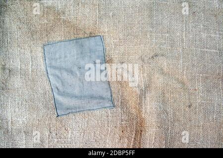 Aged vintage and weathered cloth background texture with patch. Old damaged brown rough texture Stock Photo