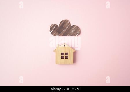 Paper dark cloud above the wooden house. Bad times, mortgage, no money concept. Flat lay. Top view Stock Photo
