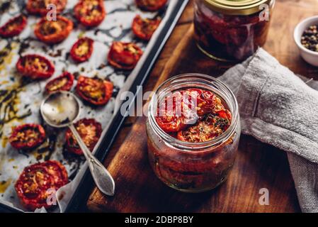 Preserving of Sun Dried Tomatoes with Herbs in a Jar Stock Photo