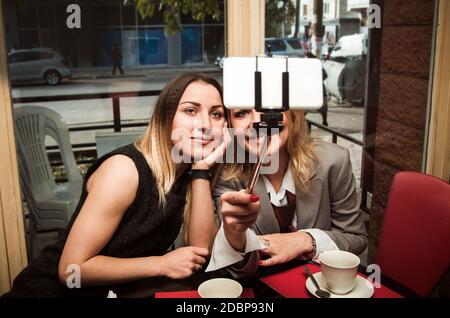 two business women in old cafe doing selfie Stock Photo