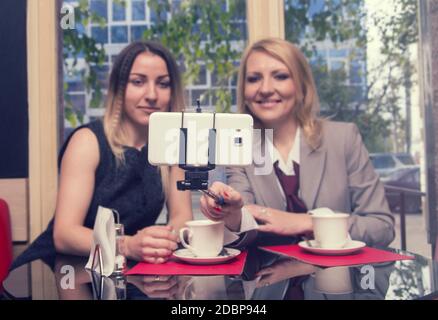 two business women in old cafe doing selfie Stock Photo