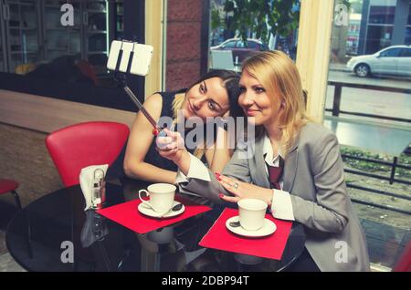 two business women in old cafe doing selfie Stock Photo