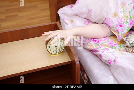 woman and alarm clock in the bedroom Stock Photo