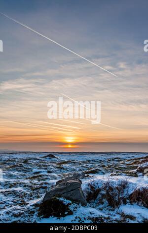 Sunset over a cold, frozen winter landscape on high moorland Stock Photo