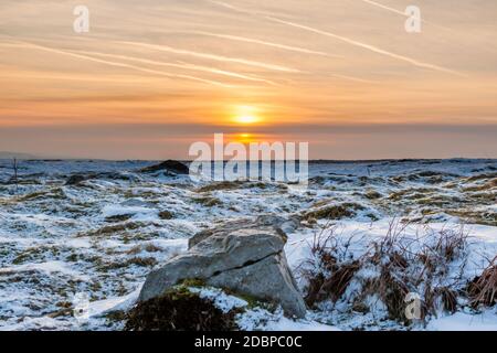 Sunset over a cold, frozen winter landscape on high moorland Stock Photo