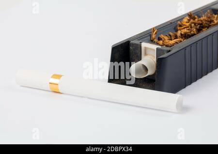 Tobbaco cigarette making machine on the white Stock Photo