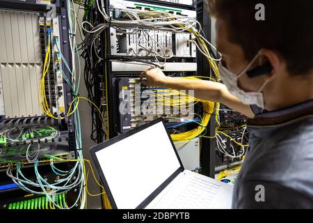 Technician engineer fixing problem with servers and data in cables room Stock Photo