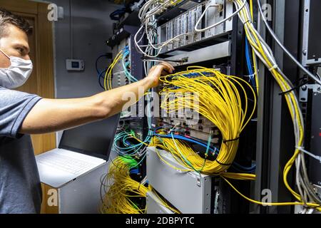 Technician engineer fixing problem with servers and data in cables room Stock Photo