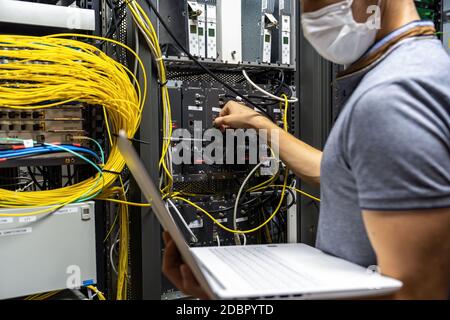 Technician engineer fixing problem with servers and data in cables room Stock Photo