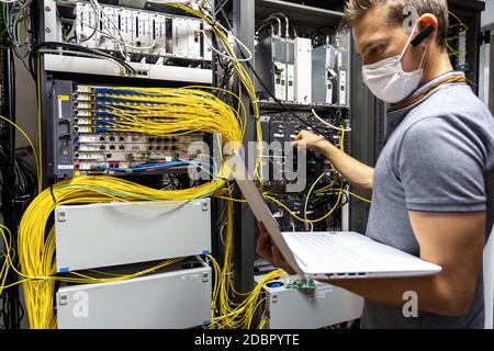 Technician engineer fixing problem with servers and data in cables room Stock Photo