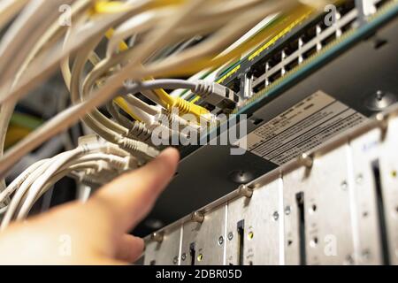 Technician pointing at cables in cables room Stock Photo