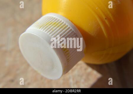 Macro of an empty plastic yellow botlle and white  cap Stock Photo