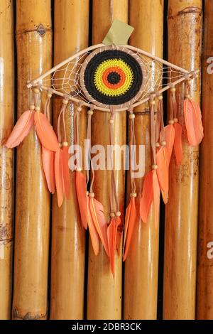 divine eye of providence dreamcatcher with colored feathers on a wodden background. Stock Photo