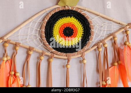 divine eye of providence dreamcatcher with colored feathers on a white background. Stock Photo