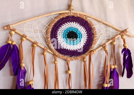 divine eye of providence dreamcatcher with colored feathers on a white background. Stock Photo