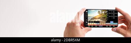 Designer Editing Video For Web On Mobile Phone Stock Photo