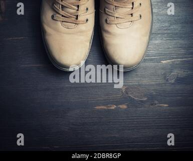 Vintage travel boots on wooden floor background. Top view. Flat lay. Stock Photo