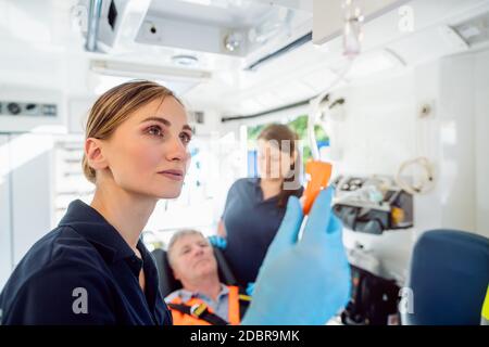 Focused paramedic looking after the drop injection in an ambulance car Stock Photo