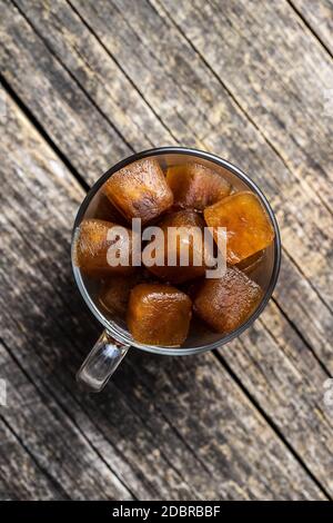 Frozen coffee. Coffee ice cubes in cup. Top view. Stock Photo