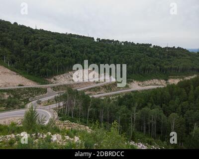 Aerial top vew of winding road in the mountains, drone shot. Altai Krai, Western Siberia, Russia. Road to Resort town Belokurikha 2 Stock Photo