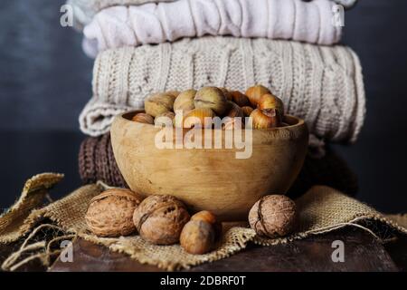 Hazelnuts and walnuts in retro wooden bowl on the desk at home. Healthy food concept. Copy space for design or text Stock Photo