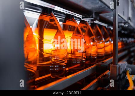 Plastic brown beer bottles on a conveyor belt close-up. Production of plastic bottles. Stock Photo