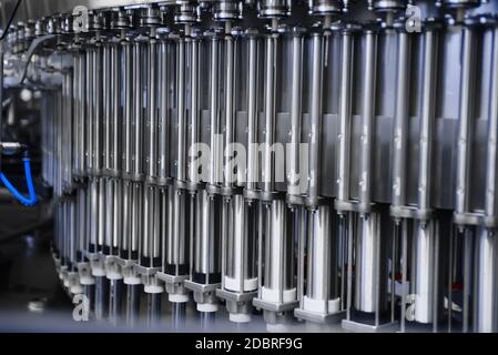 Automatic line for filling beer and water into plastic bottles. Industrial production of beverages. Capping machine Stock Photo