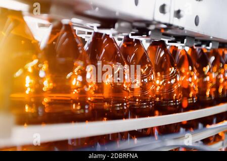 Close up of plastic bottles on a conveyor belt. Industrial production of beer. Automatic filling line Stock Photo