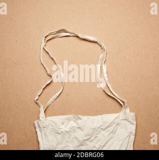 empty white textile reusable cotton shopping bag on brown background, top view, plastic rejection concept, zero waste Stock Photo