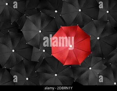 Concept image with lots of black umbrellas and a red umbrella that stands out, be unique Stock Photo