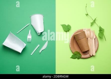 non-degradable plastic waste from disposable tableware and a set of dishes from environmental recycled materials on a green background. The concept of Stock Photo