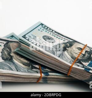 Isolated bundle of dollars. A large stack of hundred-dollar bills lies diagonally across the white background of the image. Close up. Full-contrast co Stock Photo