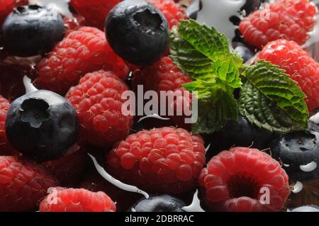Raspberries and blueberries with mint in the water Stock Photo