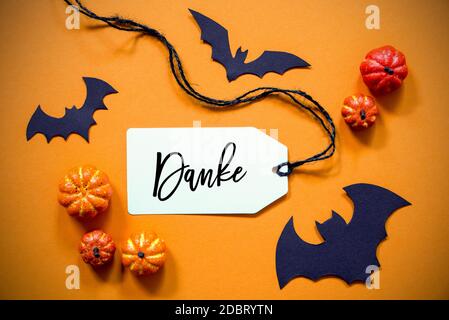 White Label With German Text Danke Means Thank You. Halloween Decoration Like Bat. Autum Pumpkin Decoration On Orange Background Stock Photo