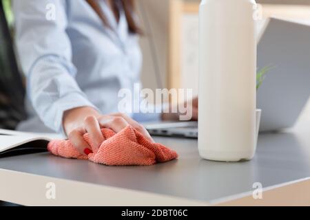 Women disinfecting workplace. New normal concept. Stock Photo
