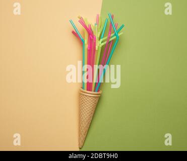 stack of plastic multi-colored cocktail tubes on a green background, close up Stock Photo