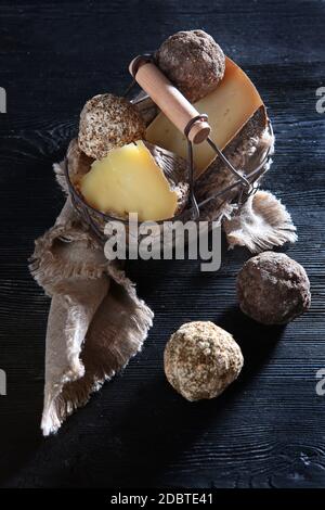 Various hard cheeses in a metal basket. Home-made craft cheeses. Organic food.Top view. Stock Photo