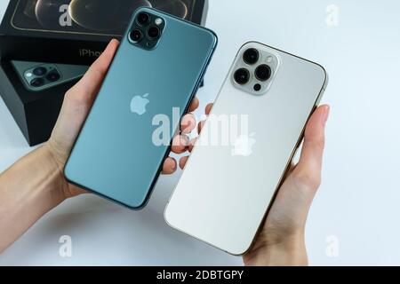 iPhone 12 Pro Max in Gold next to iPhone 11 Pro Max in Midnight Green color. Stock Photo