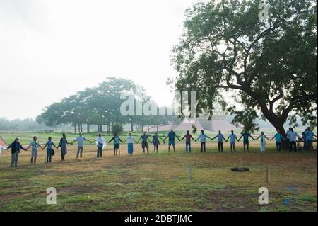 Auroville, India - February 2019: People holding hands in the Matrimandir gardens. Stock Photo