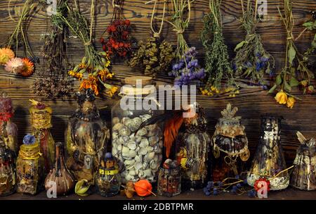 Witch laboratory with potion, elixirs, glass bottles, dry flowers ...