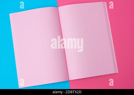 open notebook with blank pink pages on a blue background, top view, flat lay Stock Photo