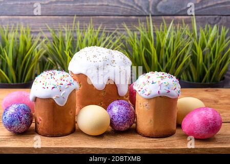 Easter cakes and Easter colored eggs on a wooden background. Religious holiday of bright Easter. Stock Photo