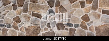 Wall made of brown and gray natural stones Stock Photo