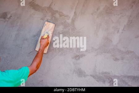 Close-up of workers using plaster trowel to plaster the walls for house construction, working ideas, and residential construction. Stock Photo