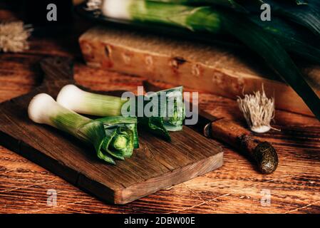 Fresh green leek on wooden cutting board Stock Photo