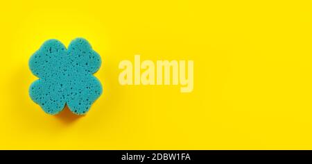 Top down view - blue bathroom sponge on yellow board, space for text right side. Stock Photo
