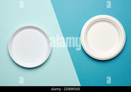 empty white plastic plates and white paper disposable plates on a blue background, top view. The concept of rejection of plastic, environmental conser Stock Photo