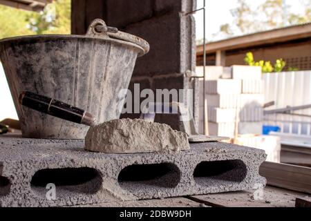 Cement or mortar and trowel with cement powder laid on bricks for construction, construction industry working concepts. Stock Photo