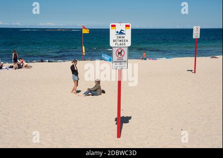 24.09.2019, Sydney, New South Wales, Australia - Warning signs informing about dangers and codes of conduct are placed in the sand at Coogee Beach. Stock Photo