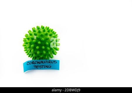 Closeup on green spiky ball as coronavirus representation and post-it note with Coronavirus Testing handwritten message isolated over white background Stock Photo